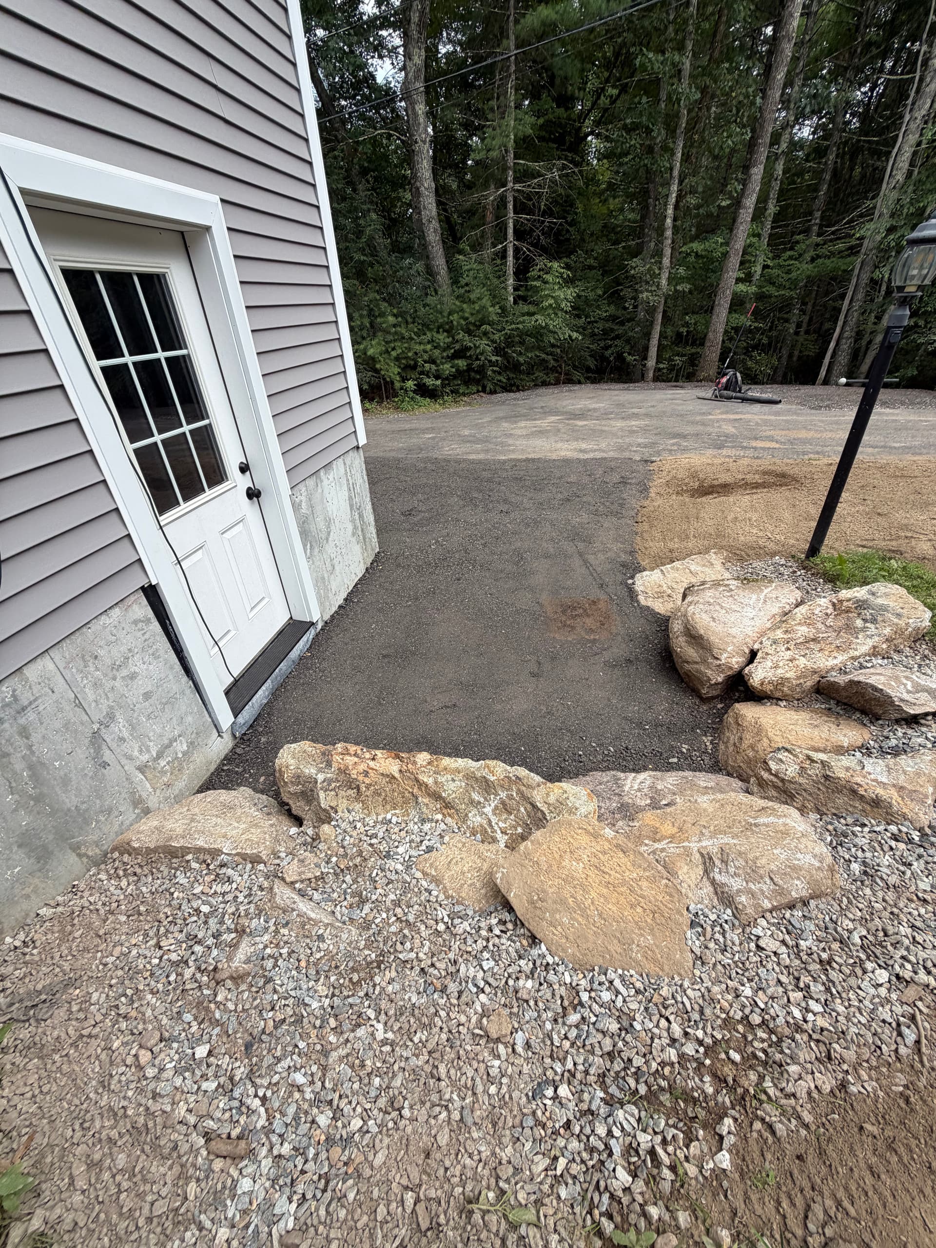 Garage Apron Regrind and Stone Wall Fixes a Drainage Problem